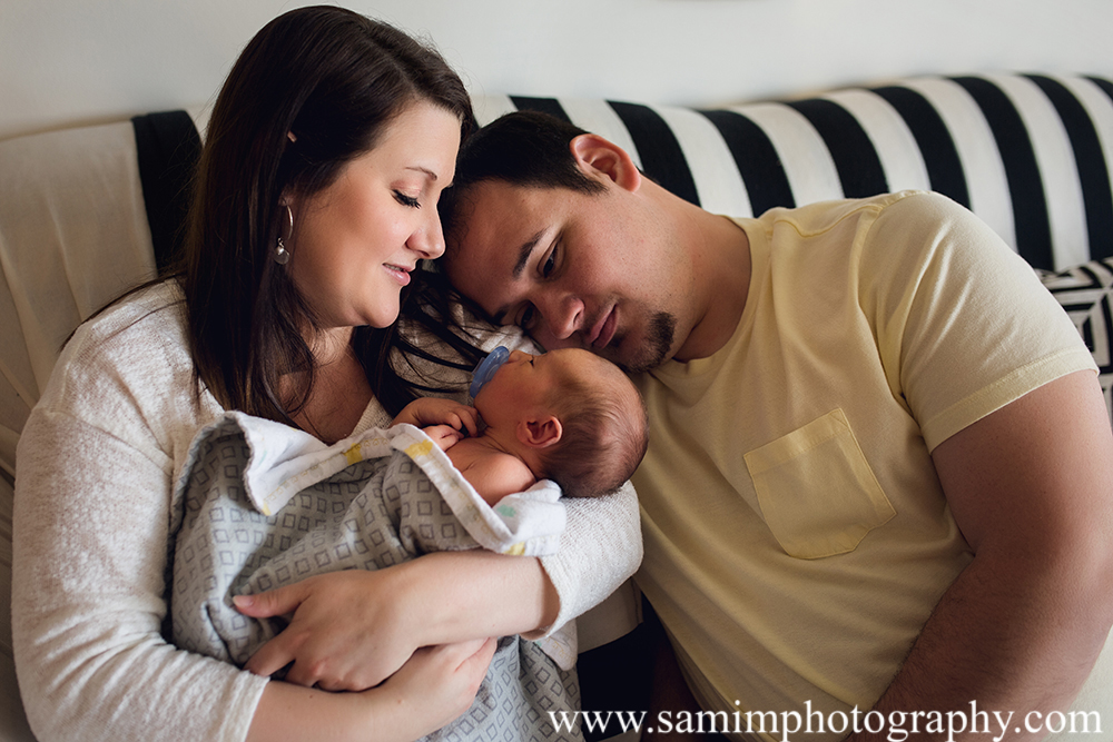 Ashburn Ga Photographer precious studio newborn session daddy, mama, and son on the couch lifestyle